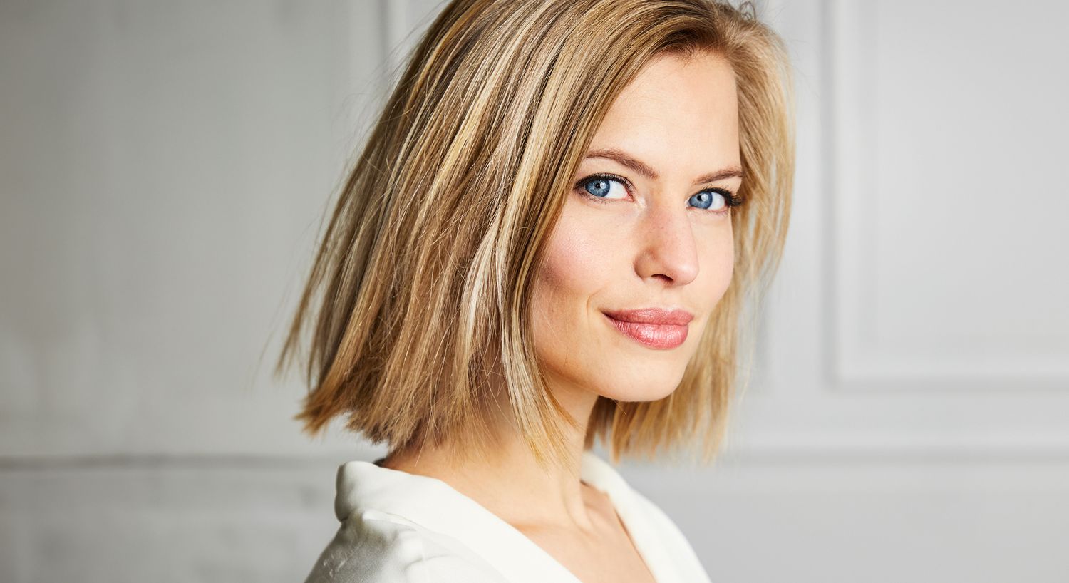Woman with short blonde hair and blue eyes.